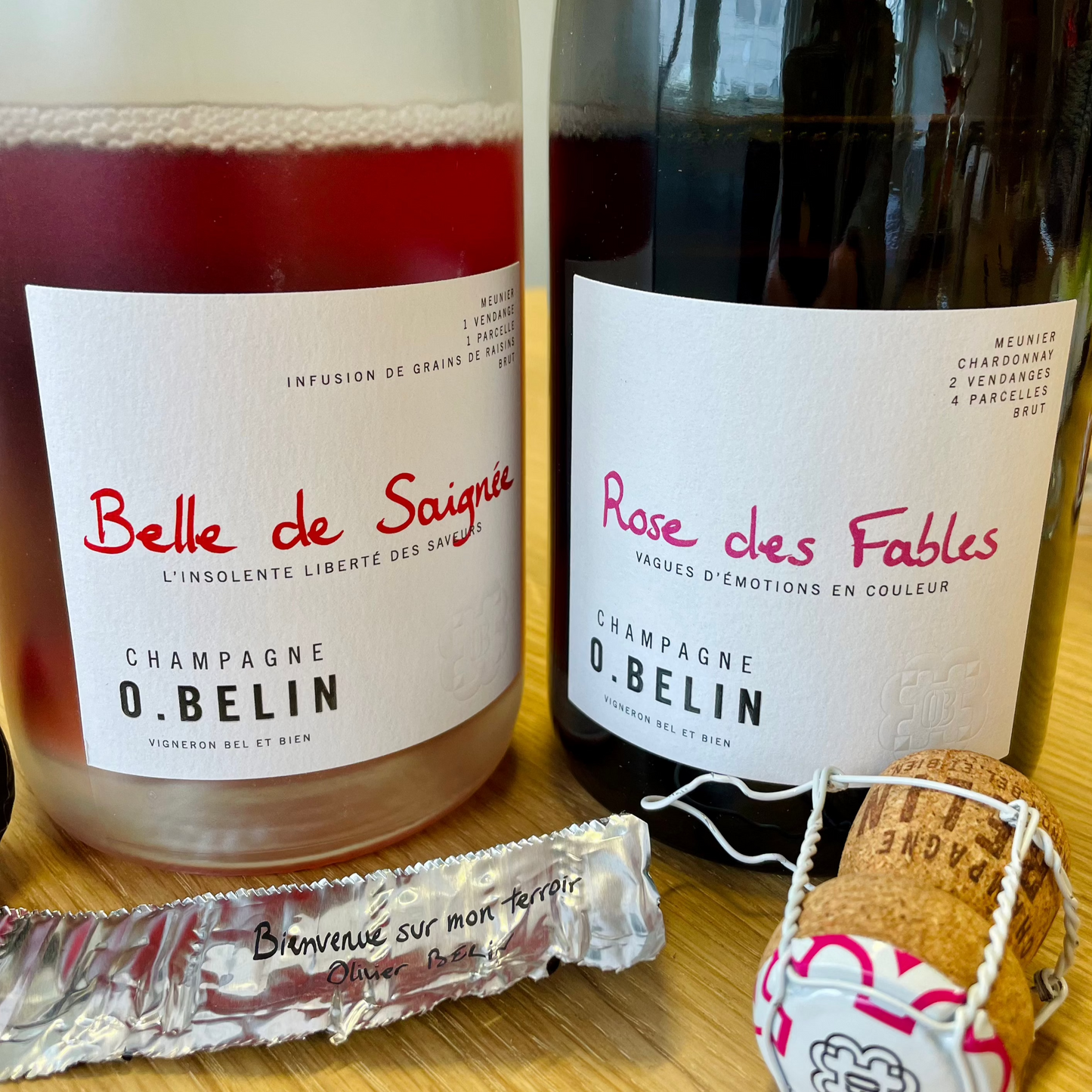 2 flasker roséchampagne, tæt på etiketterne, folie og prop. Champagne O. Belin, Belle de Saignée og Rose des Fables