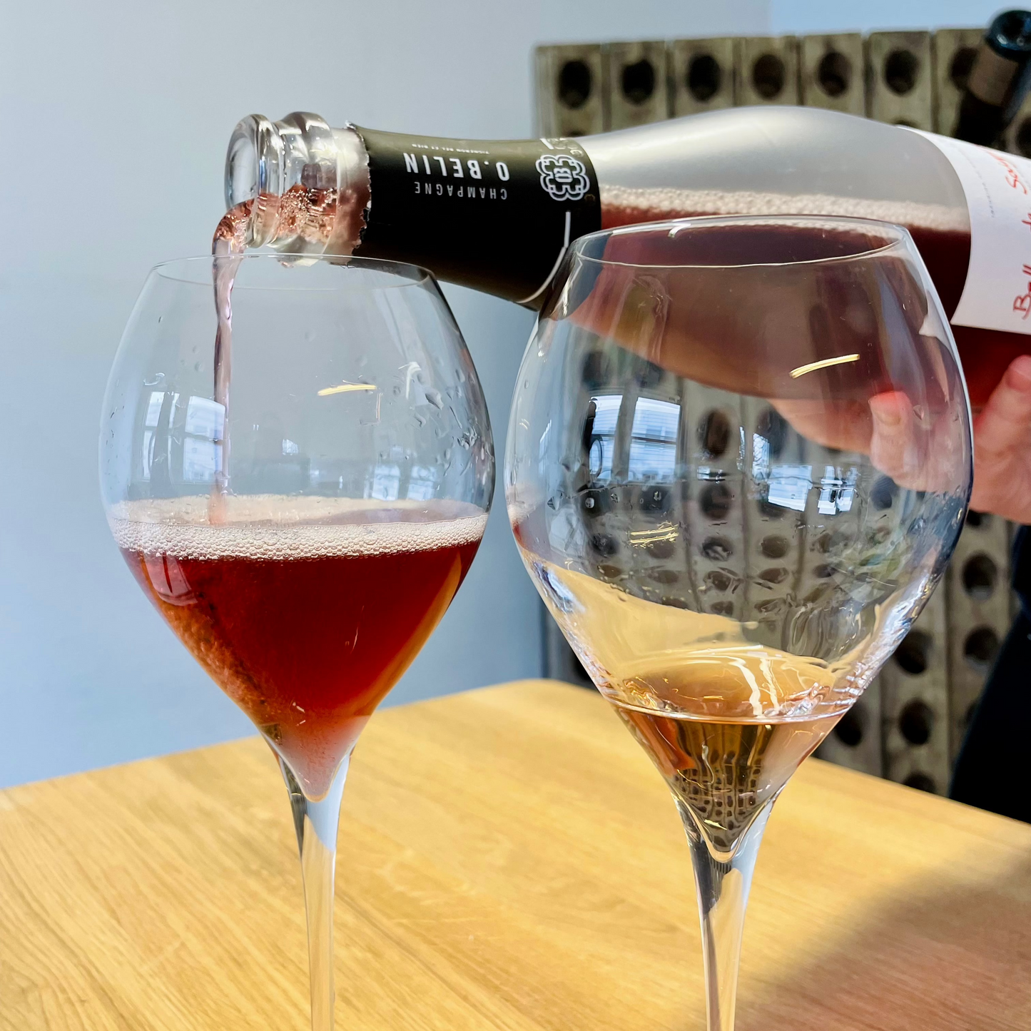der skænkes fra en flaske roséchampagne, tæt på champagneglas med roséchampagne. Champagne O. Belin, Belle de Saignée og Rose des Fables