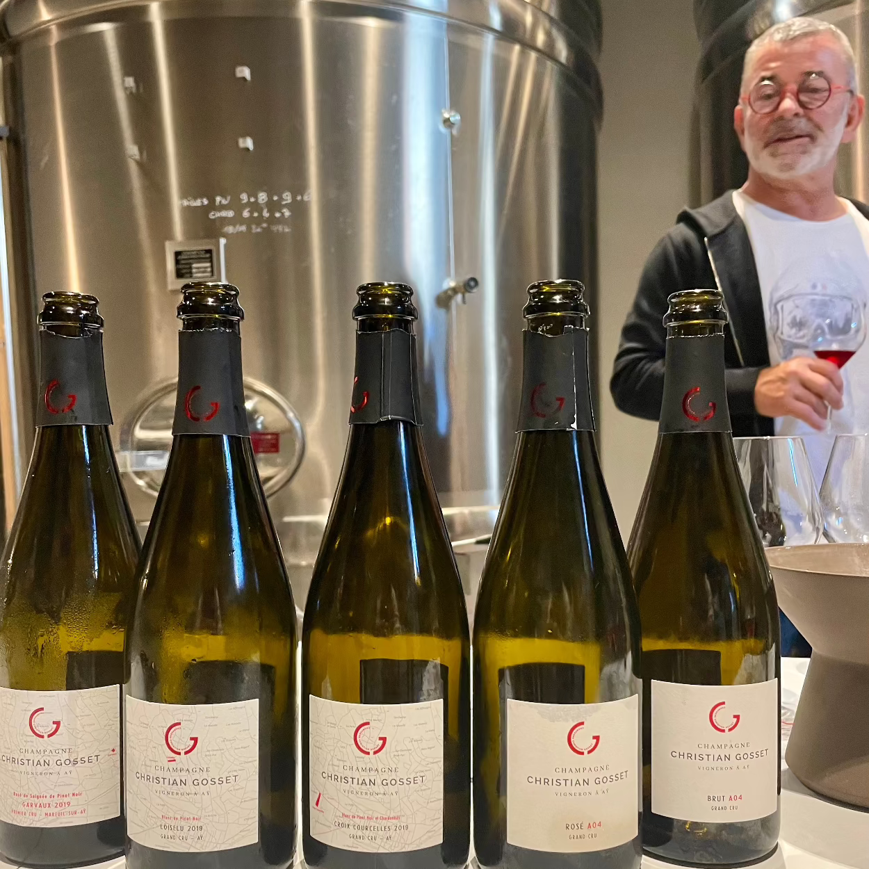 5 champagneflasker på række i produktionsområde med producent Christian Gosset i baggrunden med champagneglas, Champagne Christian Gosset Brut A04 Grand Cru, A04 rosé, Croi Courcelles 2019, Loiselu 2019, Garvaux 2019 Rosé