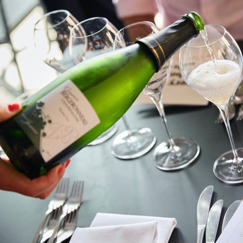 Champagne skænkes ved et dækket bord