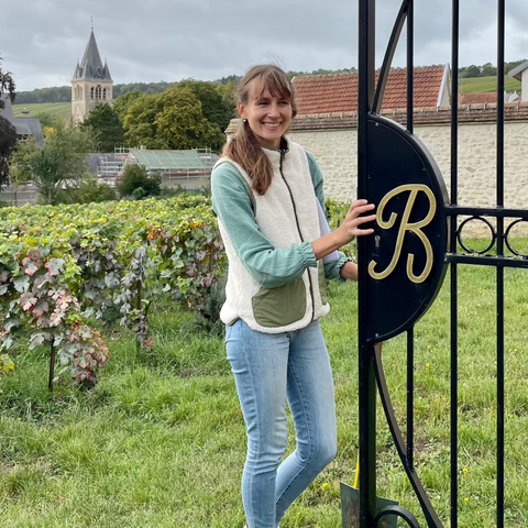 Virginie Bergeronneau ved lågen til familiens Clos - vin mark og kirke i baggrund
