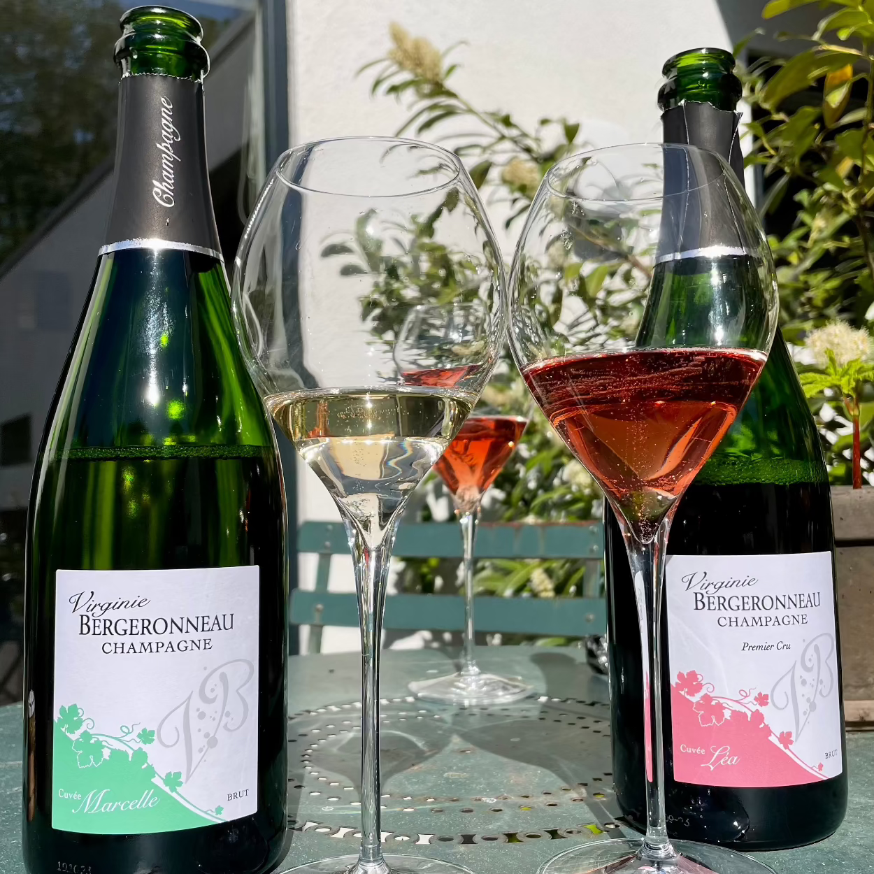 2 champagne flasker på bord udendørs med champagneglas med lidt champagne, Champagne Virginie Bergeronneau, Cuvée Marcelle og Cuvée Léa, Rose champagne